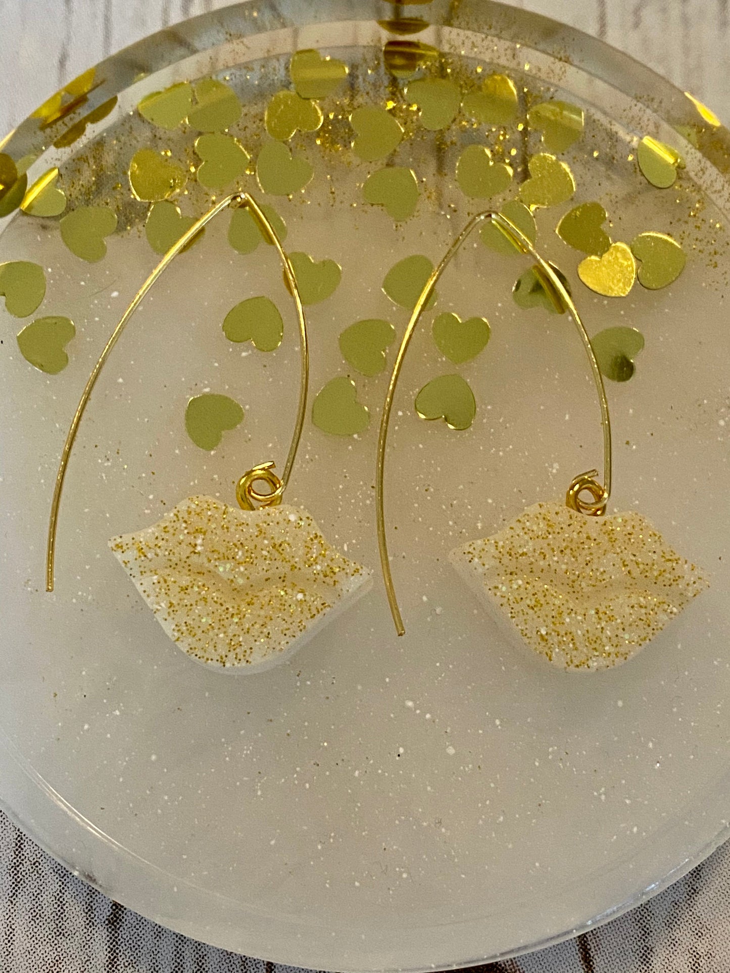 Sparkly resin lip 👄 earrings dangling from 14k gold plated hoops or danglers.