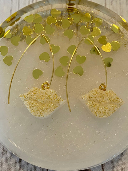 Sparkly resin lip 👄 earrings dangling from 14k gold plated hoops or danglers.