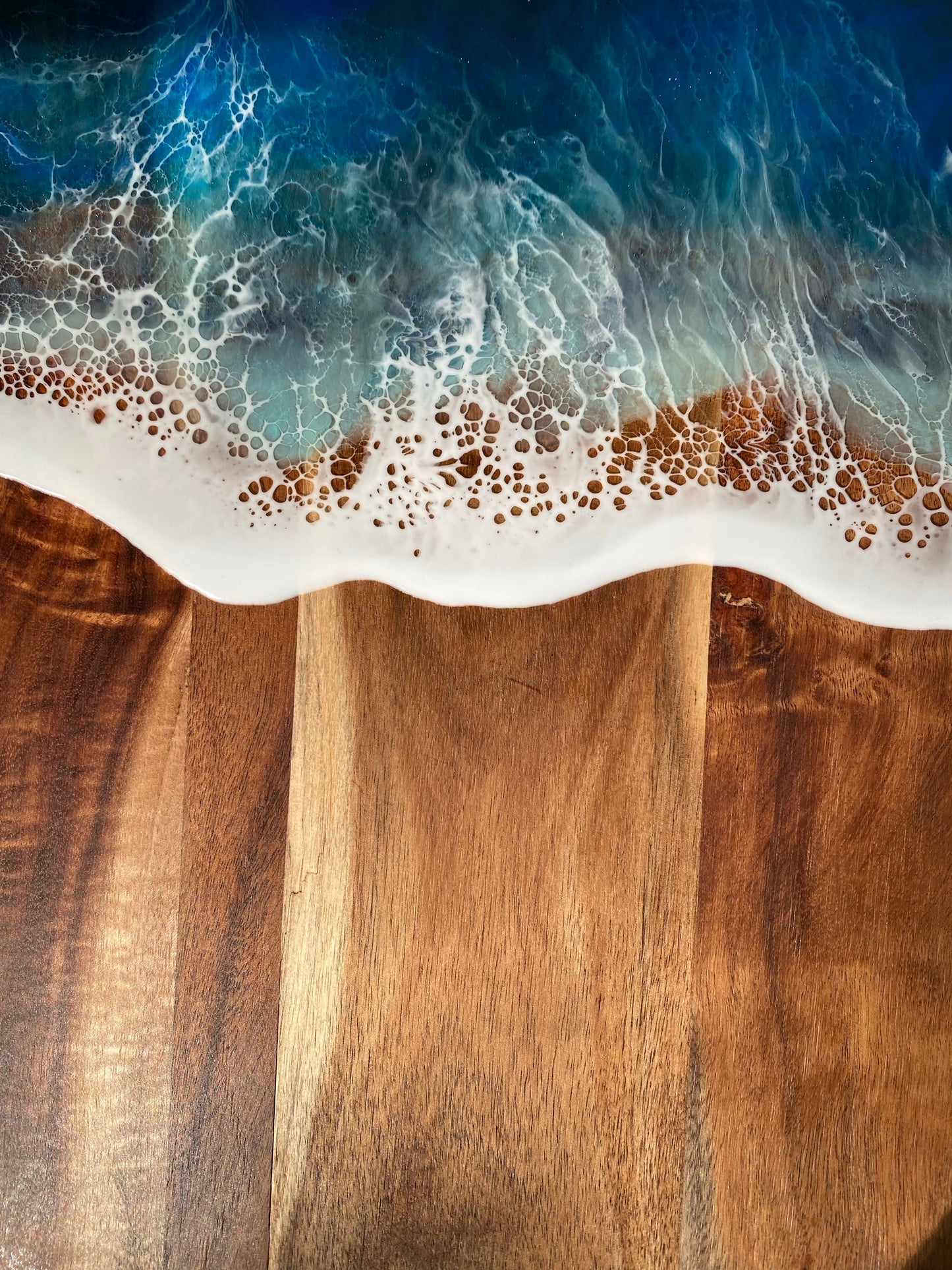 Acacia wood paddle board wth triple blue ocean waves.
