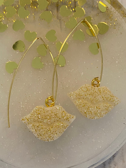 Sparkly resin lip 👄 earrings dangling from 14k gold plated hoops or danglers.